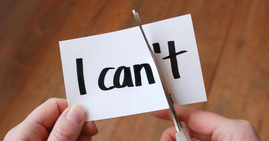 Hand cutting piece of paper "I can't"