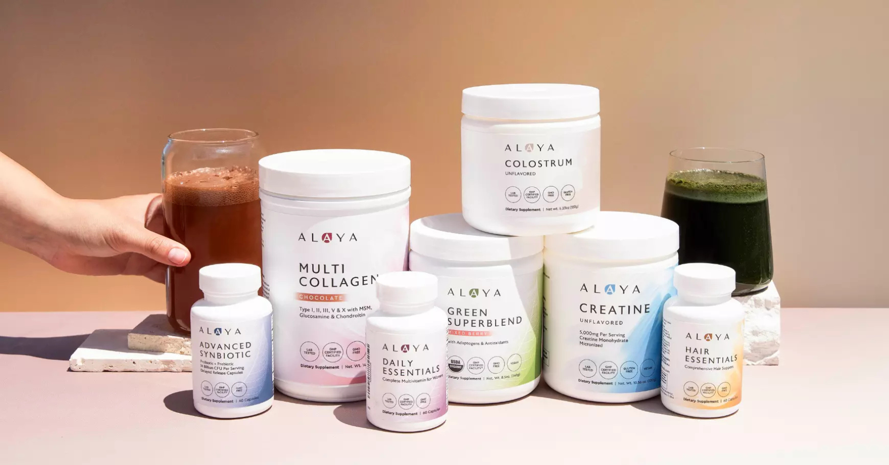 hand grabbing glass with Alaya products